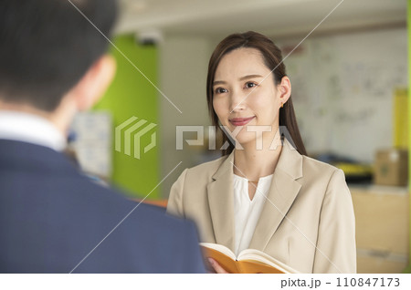 上司の指示を伺う女性 110847173