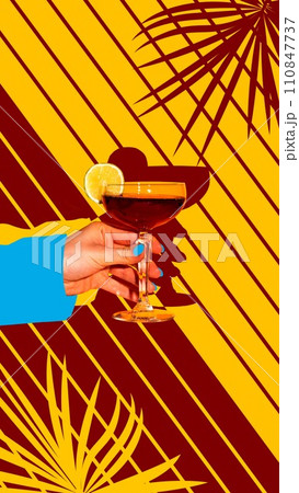 Contemporary art collage. Limelight. Woman's hand holding glass of alcohol drink with lime wedge against creative striped yellow background. Contemporary art collage. Limelight. Woman's hand holding glass of alcohol drink with lime wedge against creative striped yellow background. 110847737