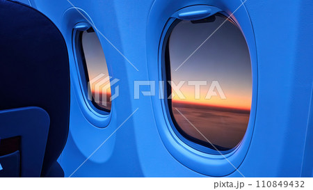 Airplane window with sunset view in orange. Airplane window with sunset view in orange. 110849432