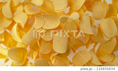 Freeze motion of flying fried potatoes chips on white background Freeze motion of flying fried potatoes chips on white background 110850834