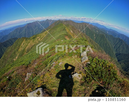 ペテガリ岳山頂からの日高山脈北部を眺める登山者の影 ペテガリ岳山頂からの日高山脈北部を眺める登山者の影 110851160