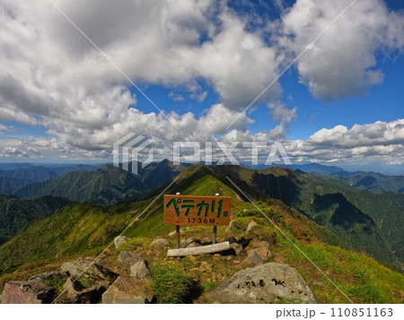 ペテガリ岳の山頂標識と日高山脈北部の山々 110851163