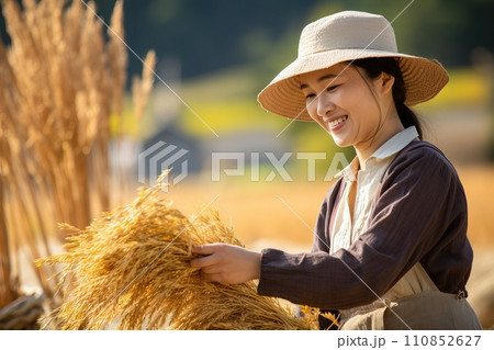 AI-generated content. A Women farmer growing rice photorealistic wears washcloths gloves and a hat and smiles in harvest day 110852627