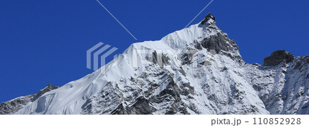 Azure blue sky over a beautiful shaped peak and glacier near Gorakshep, Nepal. 110852928