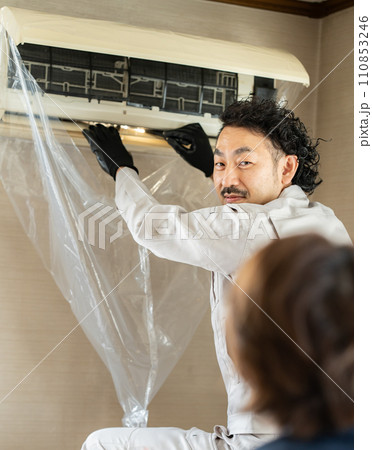 エアコンの状況説明を受ける依頼主 110853246