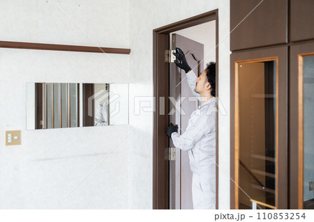 扉の蝶番を調整する職人 110853254