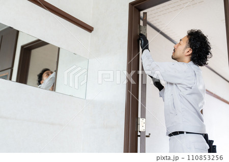 扉の蝶番を調整する職人 110853256