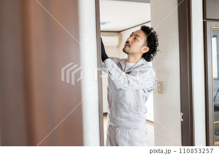 扉の蝶番を調整する職人 110853257