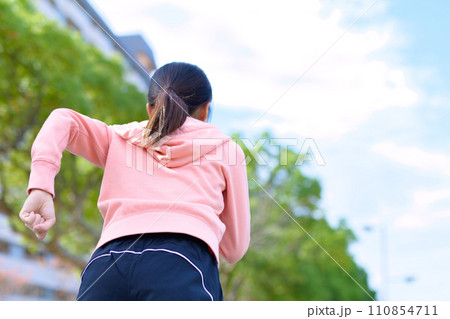 川沿いの道をジョギングする若い女性　ダイエット　ランニングウェア　後ろ姿顔無し　トリミングアップ 110854711