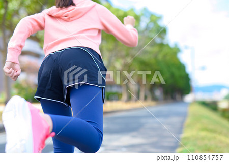 川沿いの道をジョギングする若い女性　ダイエット　ランニングウェア　後ろ姿顔無し　トリミングアップ 110854757
