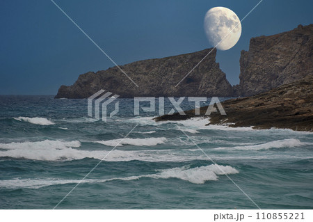Moon rising between the cliffs of a Mediterranean beach 110855221