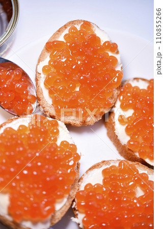 Red salmon caviar on bread and butter. A sandwich with caviar and butter on a plate. Red salmon caviar on bread and butter. A sandwich with caviar and butter on a plate. 110855266