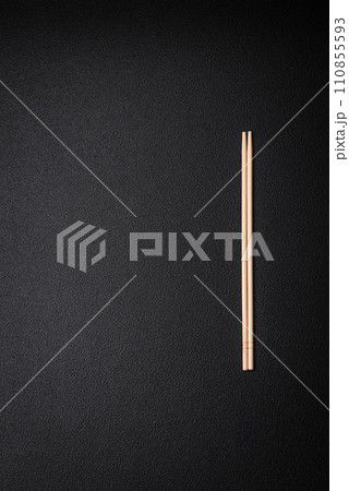 Light wooden chopsticks on a blank background as a backdrop for an Asian dish Light wooden chopsticks on a blank background as a backdrop for an Asian dish 110855593