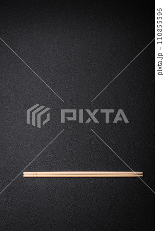 Light wooden chopsticks on a blank background as a backdrop for an Asian dish 110855596