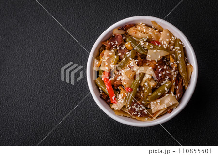 Delicious Asian dish udon with hot peppers, green beans, spices and herbs Delicious Asian dish udon with hot peppers, green beans, spices and herbs 110855601