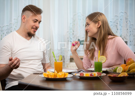 Friends talk at a table set with snacks. Friends talk at a table set with snacks. 110856099