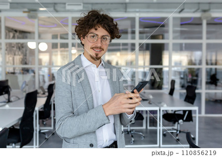 Expert young businessman with a pleasant demeanor working at his office, showcasing competence and dedication with a focused yet positive emotional state. Expert young businessman with a pleasant demeanor working at his office, showcasing competence and dedication with a focused yet positive emotional state. 110856219
