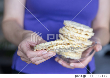 A hand holds a bowl of corn chips close-up. The process of eating a quick snack in the form of corn chips. A hand holds a bowl of corn chips close-up. The process of eating a quick snack in the form of corn chips. 110857145