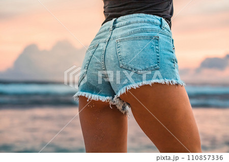 Close up photo of beautiful girl's buttocks wearing jeans at sunset Close up photo of beautiful girl's buttocks wearing jeans at sunset 110857336