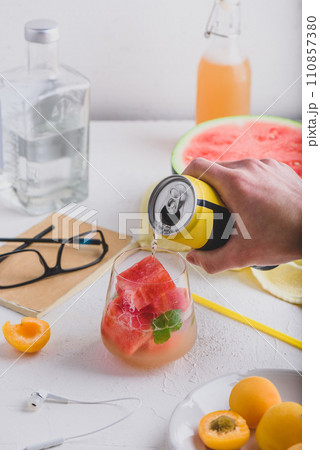 Red cocktail with frozen watermelon cubes, gin and soda 110857380