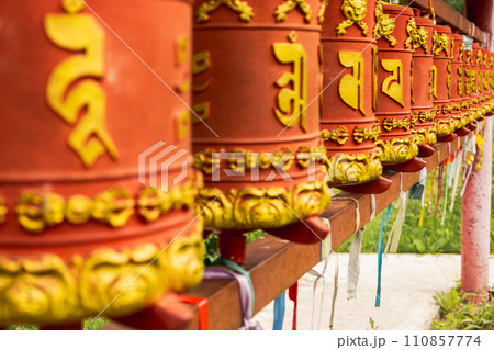 Rotating religious elements for touching turning spinning Buddhist prayer wheel at Buddhist monastery. Prayer wheels in Buddhist stupa temple. Buddhism religion concept 110857774