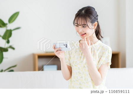 スマホを操作する女性。 スマホを操作する女性。 110859111