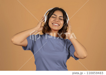 Cute young arab woman listening to music and dancing 110859483