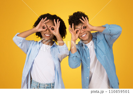 Playful and happy African American couple making binoculars with their hands Playful and happy African American couple making binoculars with their hands 110859501
