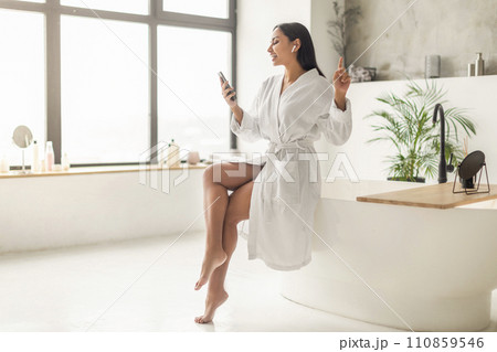 Joyful attractive indian woman singing songs in bathroom Joyful attractive indian woman singing songs in bathroom 110859546