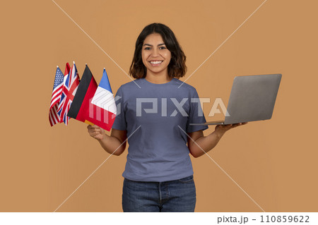 Cheerful young arab woman student with many different flags, laptop 110859622