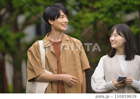 笑顔で会話する大学生の男女 110859639
