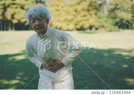 おなかが痛む公園の60代女性 おなかが痛む公園の60代女性 110861994