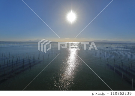 有明海の海苔養殖場の上に輝く大きな太陽 110862239