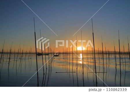 沈みゆく夕日が美しい有明海での海苔養殖の作業風景 沈みゆく夕日が美しい有明海での海苔養殖の作業風景 110862339