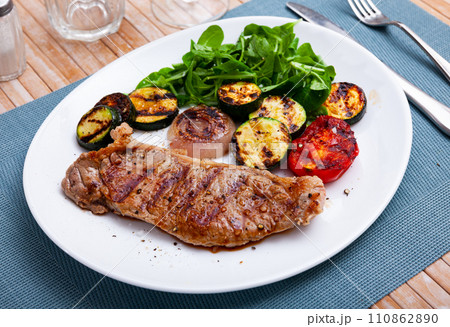 Beef with grilled eggplant, onion, tomatoes and fresh greens 110862890