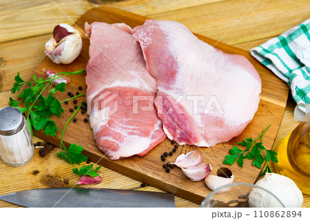 Preparation of raw pork cinch parsley and garlic on wooden board 110862894