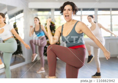Hispanic female fitness instructor leading Zumba class in Christmas studio Hispanic female fitness instructor leading Zumba class in Christmas studio 110862942