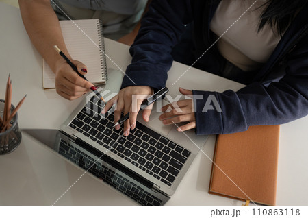 Top view of two women are discussing work and working together in the office. Top view of two women are discussing work and working together in the office. 110863118