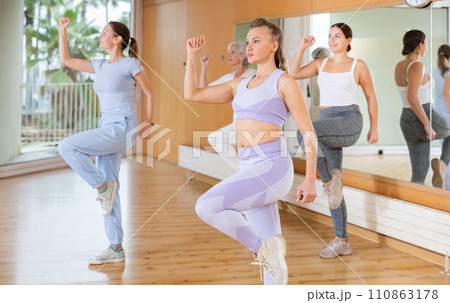 Active middle-aged woman practicing aerobic dance in training hall Active middle-aged woman practicing aerobic dance in training hall 110863178