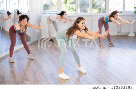 Young female teacher conducts modern dance lessons for group of girls 110863198