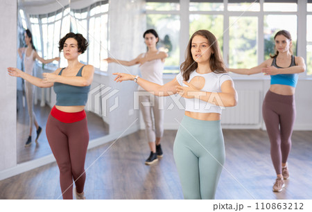 During dance lesson, girls practice and memorize movements to perform slow classical waltz dance. 110863212