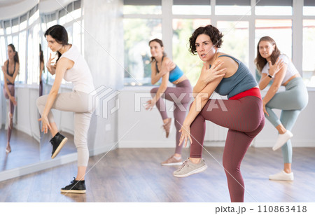 Female teacher conducts modern dance lessons for group of girls 110863418