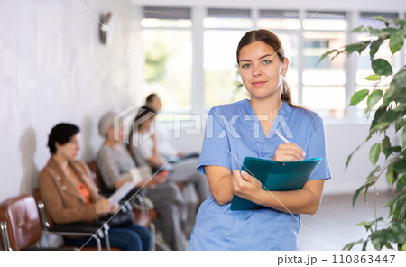 Doctor of clinic in bathrobe is standing in waiting hall and waiting for arrival of patients. 110863447