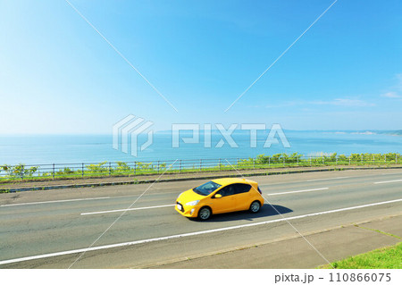 北海道　青空と海沿いの道を走る車 110866075