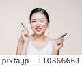 woman hold mascara isolated on beige background 110866661