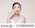 asian woman smile looking happy applying makeup with puff makeup to her face 110866666