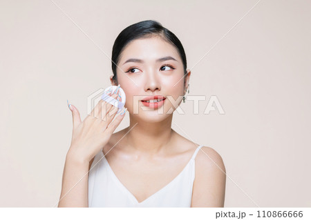 asian woman smile looking happy applying makeup with puff makeup to her face asian woman smile looking happy applying makeup with puff makeup to her face 110866666