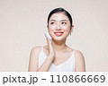 asian woman smile looking happy applying makeup with puff makeup to her face 110866669