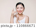 beautiful young asian woman with closed eyes holding glass of clear water near face 110866671