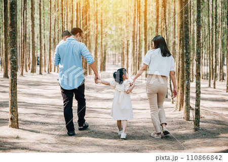 Asian happy family walking through a park in the summer, with the parents holding the hands of their three children, Happy family day Asian happy family walking through a park in the summer, with the parents holding the hands of their three children, Happy family day 110866842